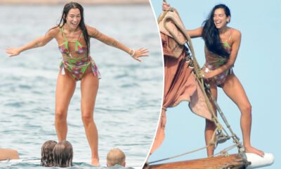 Dua Lipa leaps into the ocean, balances on surfboard while laughing with chums